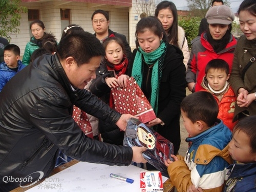 今年3月2日，在“走近留守儿童”活动中，许书记（前排左一）为小学生发放书包